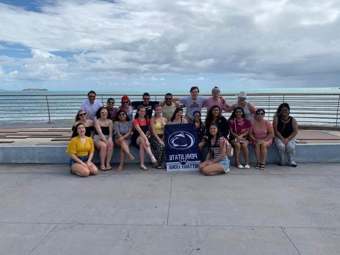 group of students and faculty in front of an ocean in Puerto Rico